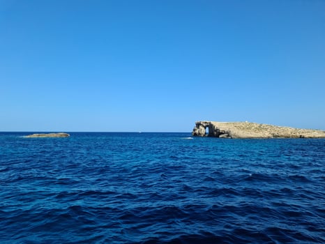 Blue Lagoon Comino Island featuring a natural arch facing the deep blue sea in Malta photo