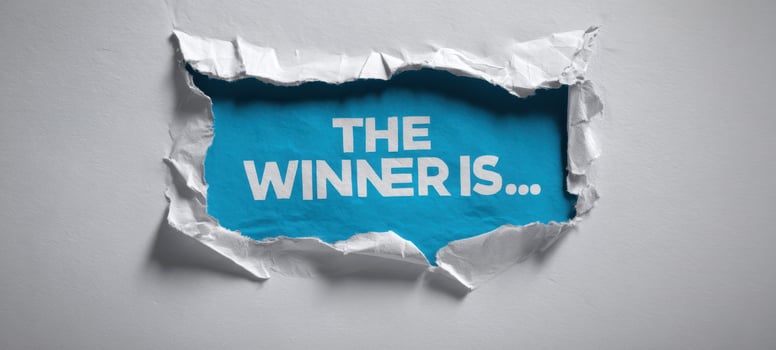 The winner is revealed through a creative torn paper design in vibrant blue. photo