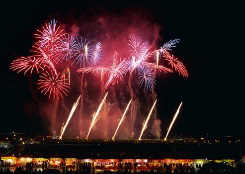 a large group of people watching a fireworks display. No location photo