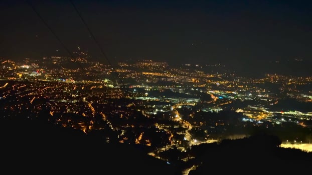 A breathtaking aerial night view showcasing the stunning city lights sprawled from a mountain peak photo