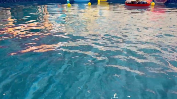 A Vibrant Pool Scene Showcasing Colorful Floats Set Against the Majestic Sunset Sky photo