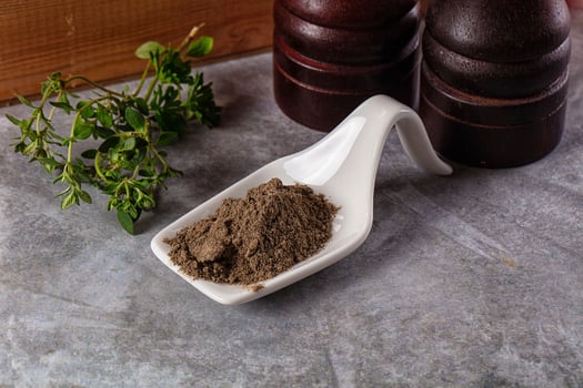 A white scoop with a brown powder on it photo
