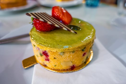Colorful dessert with strawberries and decorative chocolate on a plate in a vibrant cafe setting photo