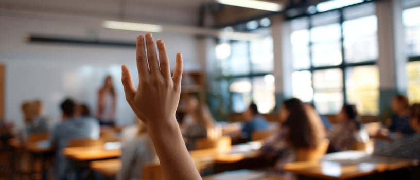 The hand raised in a dynamic classroom setting filled with eager learners. photo