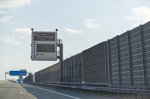 Digital Traffic Sign on Highway Displaying Delay Warning photo