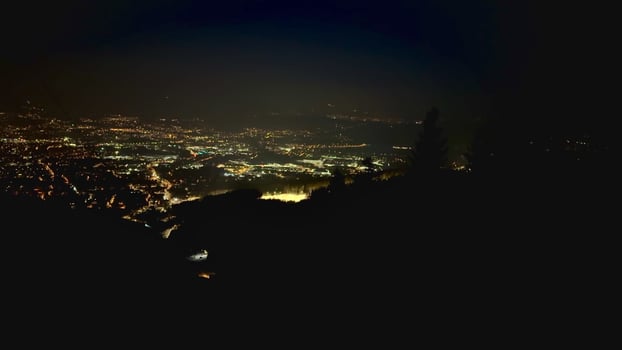A city at night with a mountain in the background photo