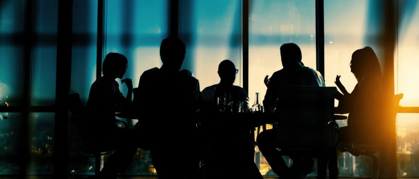 The silhouettes of people gathered for a business meeting during sunset. photo