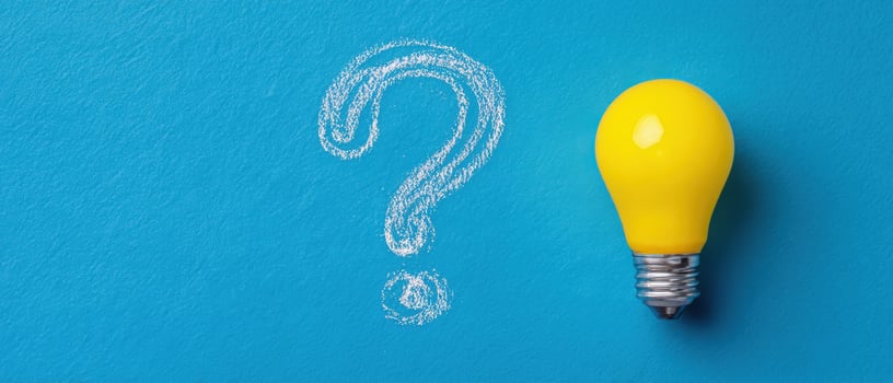 The yellow light bulb illuminating a question mark on a blue background. photo