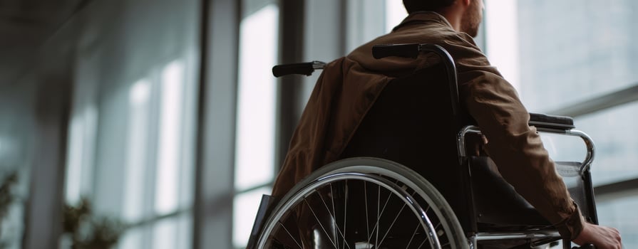 The individual in a wheelchair reflecting on life in a modern interior setting. photo