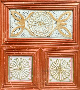 Intricate wooden door design featuring floral patterns and rich colors in a historic location photo