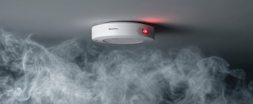The smoke detector monitoring safety with red light in a smoky environment. photo