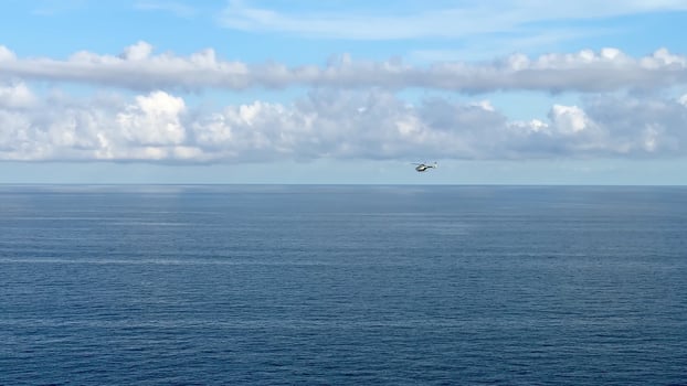 A stunning aerial view showcasing the vast ocean, fluffy clouds, and a ship navigating peacefully photo