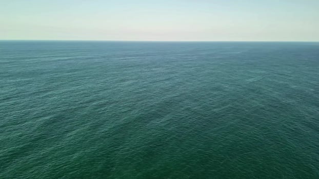Aerial View of a Calm and Serene Ocean with Numerous Ships Present in the Distant Horizon photo