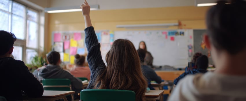 The student raising hand in an engaging classroom environment for active participation. photo