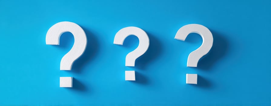 The White Question Marks Representing Inquiry and Curiosity on a Blue Background photo