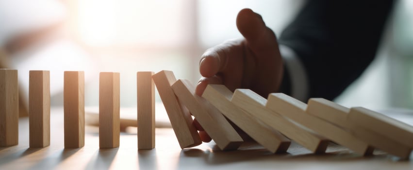 The Hand Preventing Dominoes from Falling in a Strategic Decision Moment photo