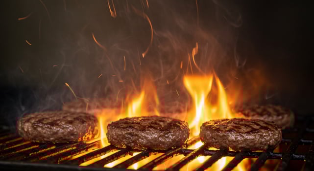 Grilled Burgers Cooking Over Flames on Hot Grill photo