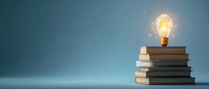 The Lightbulb on Top of a Stack of Books Representing Ideas and Knowledge photo