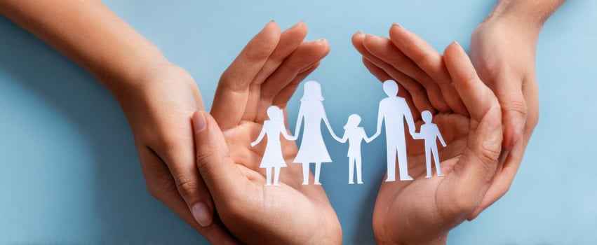 The paper cutout family nestled in caring hands symbolizing protection and love. photo