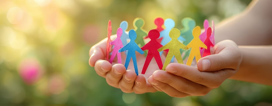 The hands holding colorful paper figures representing unity and community. photo