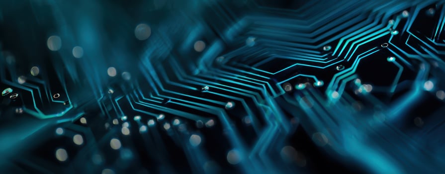 The intricate circuit board design illuminated by glowing blue light. photo