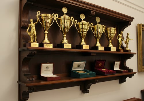 Wooden shelf with gold trophies and awards photo