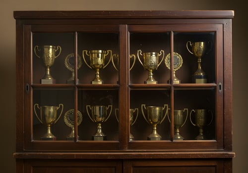 Wooden cabinet displaying gold trophies photo