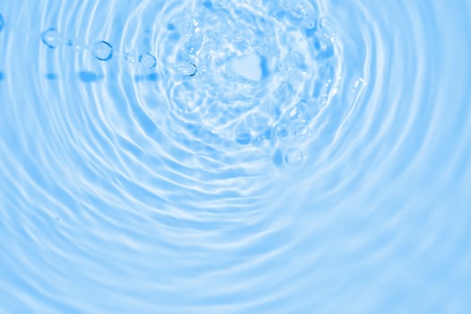 Water ripple background with blue sky and water droplets photo