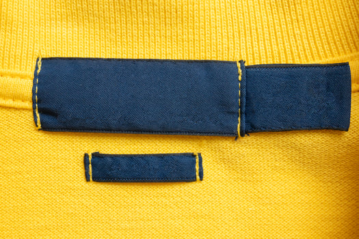 A close up of a yellow shirt with a blue tag photo