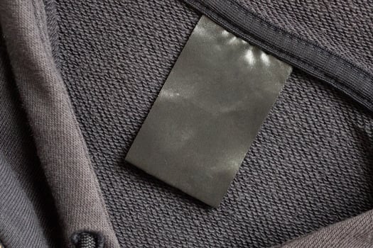 A black tag is attached to a gray sweater photo
