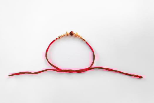 Elegant Detailed Rakhi Bracelet with Beads and Red Thread for Celebration. photo