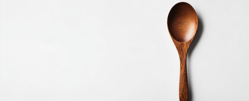 Simple wooden spoon on white surface photo
