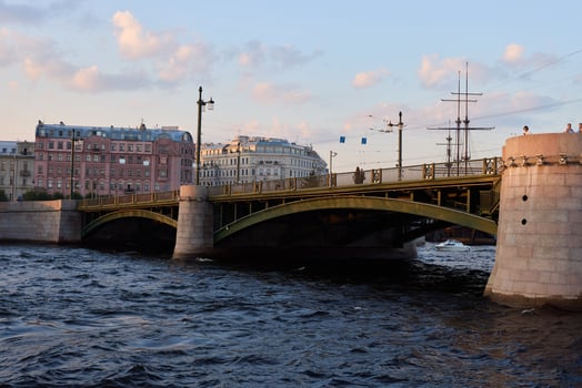 A Beautiful and Historic Bridge Over the River During a Stunning Sunset in an Urban Landscape photo
