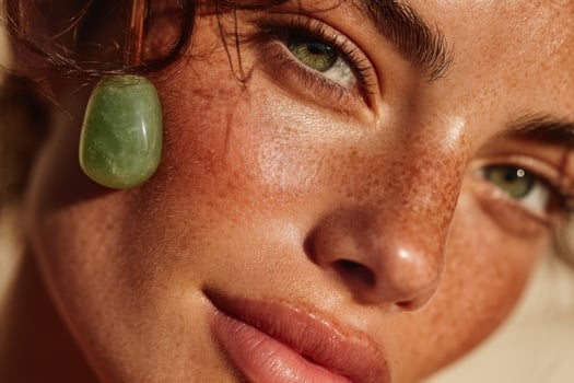 A woman with freckled skin and green jade stone photo