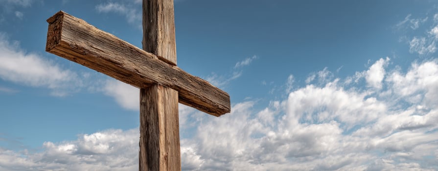 The wooden cross standing majestically against a beautiful blue sky. photo