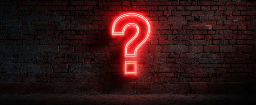 The Neon Question Mark Illuminating a Brick Wall in an Urban Setting photo