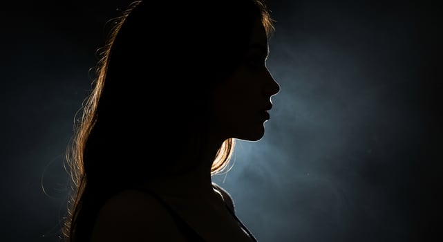 Silhouette of Woman's Profile Against Dark, Smoky Backdrop photo