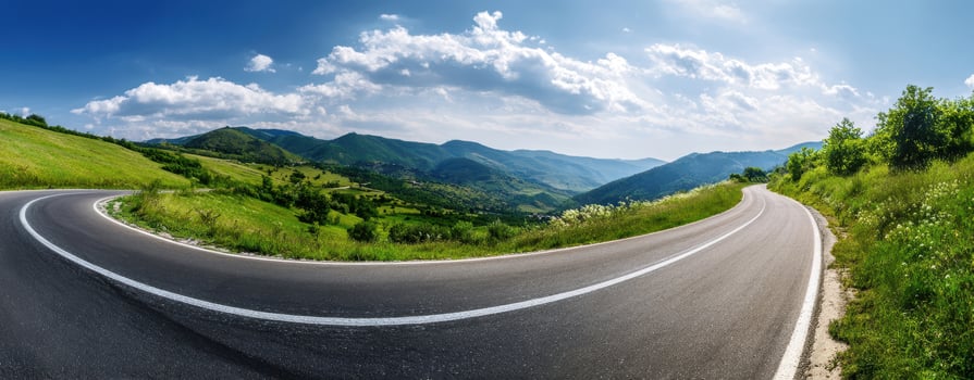The Curved Road Through Beautiful Mountainous Landscape Under Clear Blue Skies photo