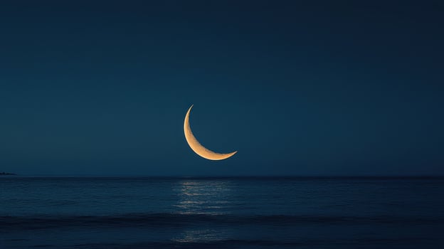 Crescent moon over tranquil ocean at night photo