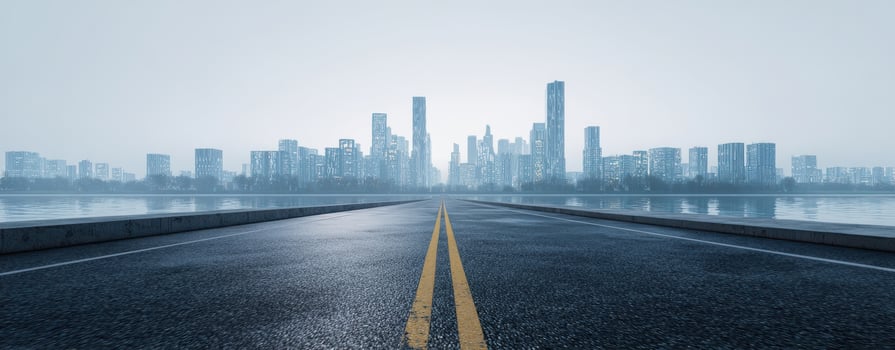 The empty road leading towards a misty urban skyline. photo