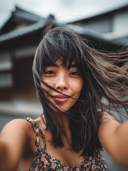 A woman taking a selfie with her hair blowing in the wind photo