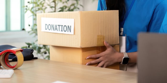 Volunteer lifting donation boxes with care and teamwork photo