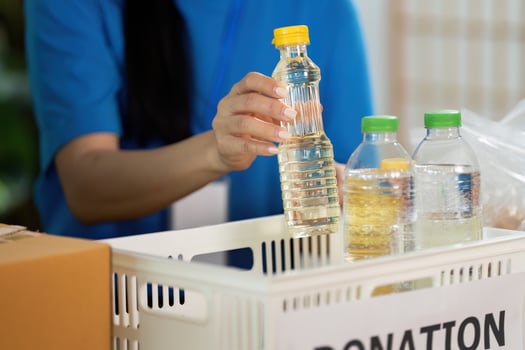 Volunteer sorting donations with water bottles and snacks photo