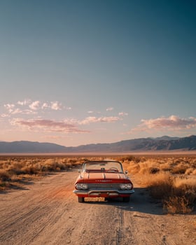 Solitary vintage convertible left on arid desert road with peeling paint and dry grass emphasizing stillness and cinematic desert narrative photo