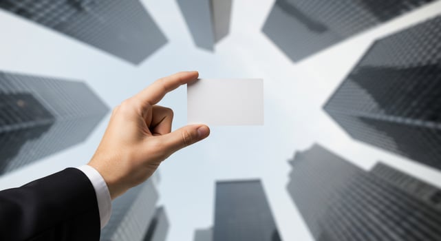 Businessman Holding Blank Business Card Against Cityscape photo