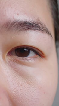 A melancholic close-up of an Asian woman's eye photo
