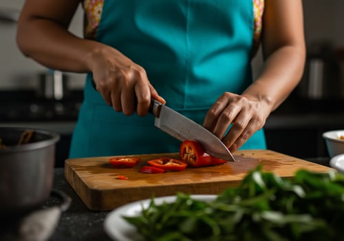 Cutting red chili peppers in kitchen for meal preparation. Home cooking concept photo