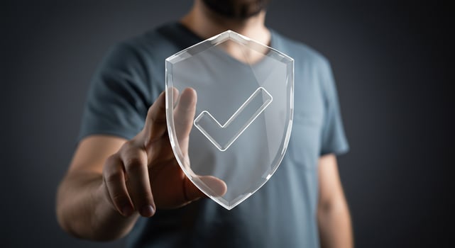 A man holding a transparent shield with a check mark photo
