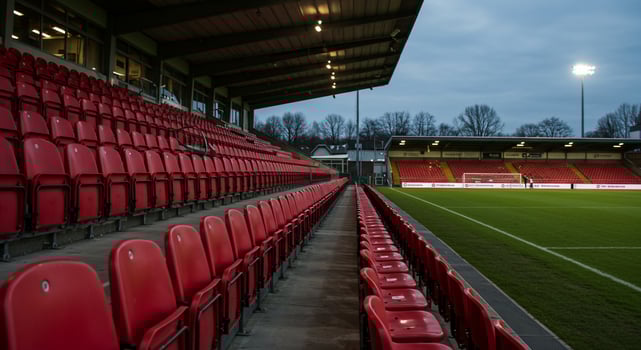 Red seats in a stadium with a light shining on them photo
