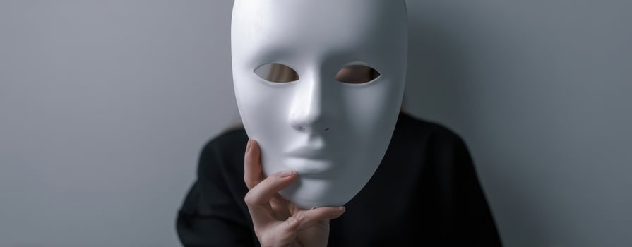 The white mask held by a person in a mysterious and artistic setting. photo